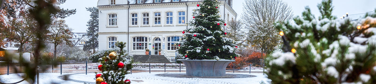 Weihnachtlich geschmückter Platz am Timmendorfer Strand mit Schnee und festlicher Dekoration.